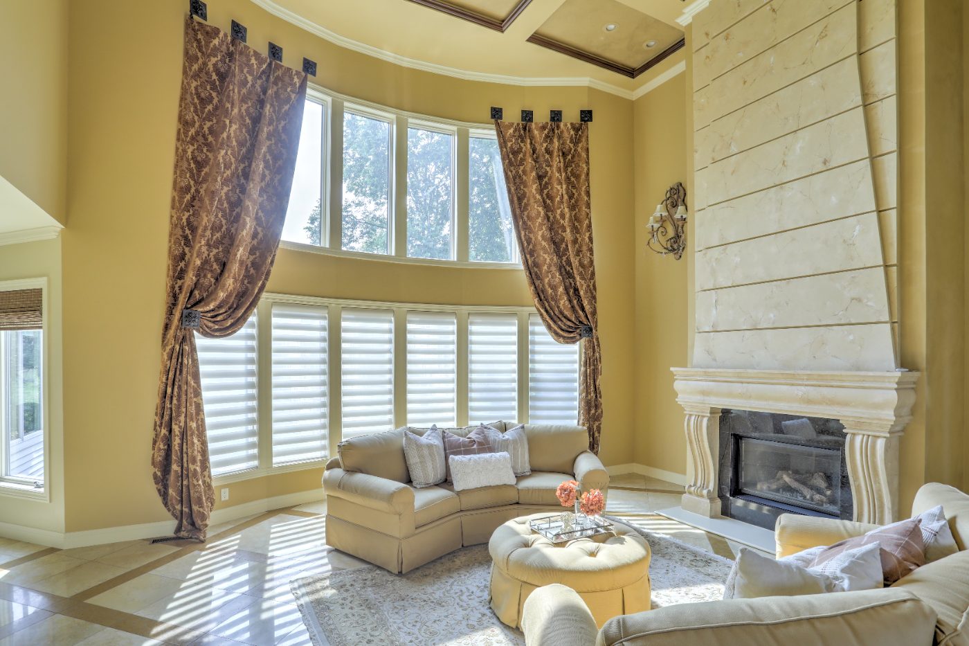 Great room with curved window wall and marble fireplace